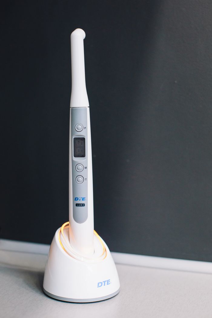 services-01 Close-up of a dental ultrasonic scaler on its charging base, highlighting advanced technology.